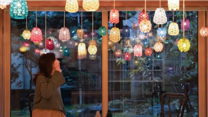 ガラス工芸のランプに囲まれてくつろぐ女性