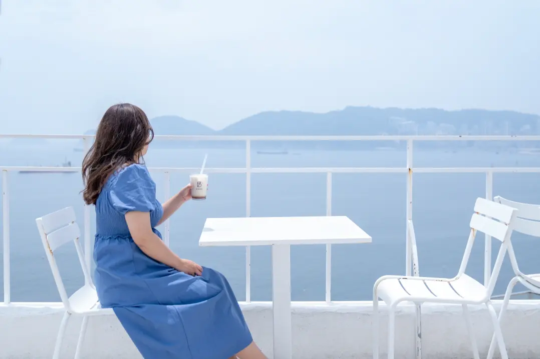 寄港地のカフェテラスでリラックスする女性